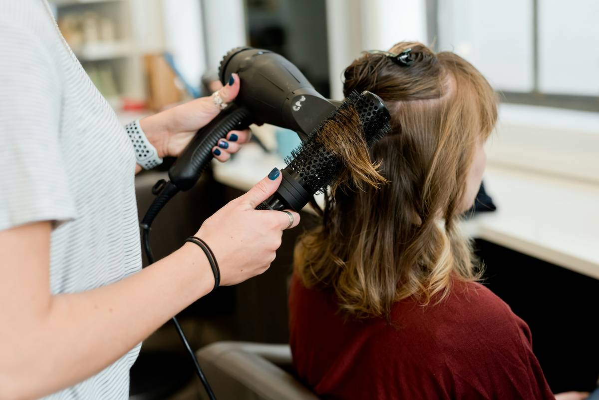 Stylist palm-rolling Scalp-Friendly hair twists on client with relaxed tension at roots