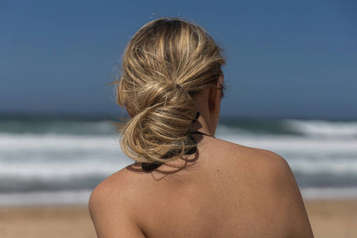 Woman applying Minimal Tension hair twists with relaxed grip near roots