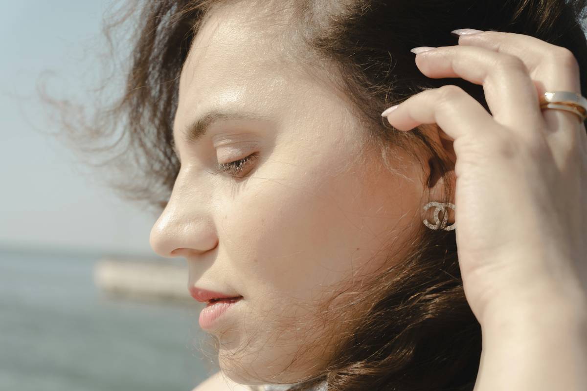 Woman applying jojoba oil while twisting sections of Moisturized Hair